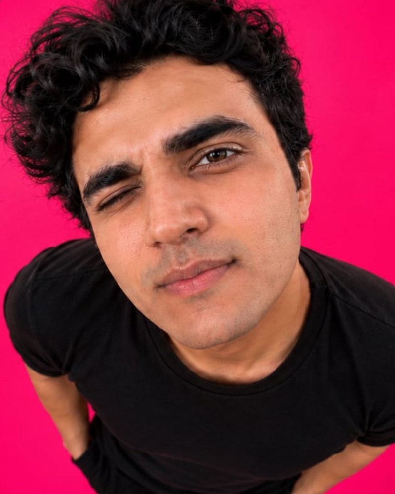 Kunal, co-founder of editNad, winking against a pink background