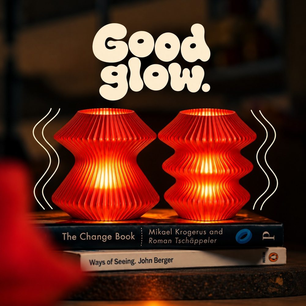 Two glowing red Muvelo lamps on books with the line Good glow
